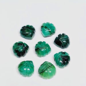 Puede incluir: Ocho cabujones de piedra preciosa esmeralda verde tallados en forma de hojas. Las piedras preciosas son facetadas y tienen un color verde oscuro.