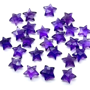May include: A collection of 20 purple amethyst star-shaped gemstones. The gemstones are faceted and have a shiny finish.