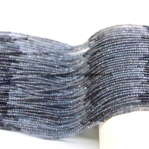 Peut inclure: Un brin de petites perles de pierres précieuses facettées, grises et bleues. Les perles sont enfilées sur un fil fin et disposées en spirale. Les perles mesurent environ 2 mm de diamètre. Le brin mesure environ 10 pouces (25 cm) de long. www.etsy.com/shop/multistonecreations