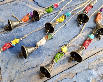 Sinos de bruxa para pendurar com sinos de latão decorados com lebres e pássaros, sino de vento com luas e estrelas, sinos de vaca em um cordão, enfeite de porta.