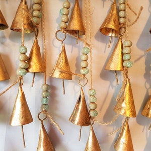 One windchime with 6 cone shaped cow bells on a string and light blue handmade ceramic crackled beads, metal bronze copper gold brass color