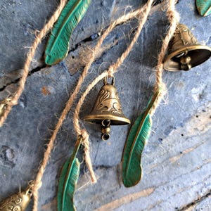 Hanging witch bells with brass bells decorated with hares and birds, windchime with feathers, cow bells on a string, unique door hanger