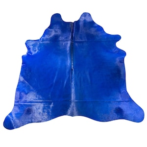 Può includere: Un tappeto in pelle di mucca blu brillante con una texture morbida e pelosa. Il tappeto è fatto di vera pelle di mucca e ha un aspetto naturale e organico.