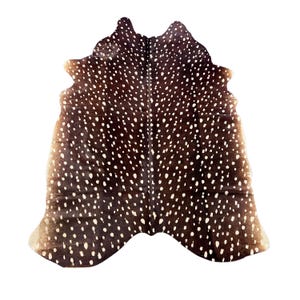 May include: A brown and white cowhide rug with a distinctive spotted pattern. The rug has an irregular shape and a natural, organic aesthetic. The hide is a rich brown colour with numerous white spots, creating a striking contrast. Suitable for home decor.