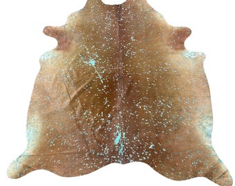 May include: A brown cowhide rug with a unique turquoise and white speckled pattern. The rug has a natural shape and texture, adding a rustic and stylish touch to any room. This decorative rug is perfect for adding warmth and character to a space.