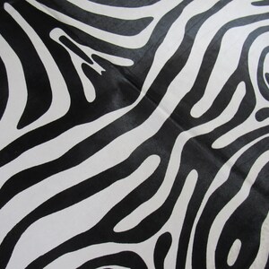May include: Black and white abstract zebra print fabric with a wavy pattern.