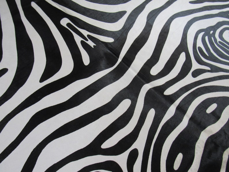May include: Black and white abstract zebra print fabric with a wavy pattern.