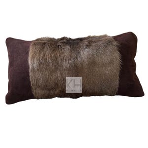 May include: A brown suede pillow with a long strip of brown fur in the center.