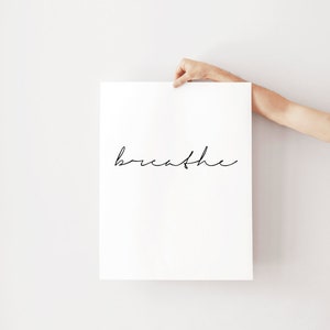 K&ouml;nnte beinhalten: Ein wei&szlig;er Poster mit dem Wort "breathe" in schwarzer Kursivschrift.