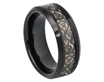 May include: A black tungsten carbide ring with a white Celtic knot design. The ring has a beveled edge and a polished finish.