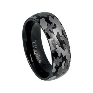 May include: Black titanium ring with a camouflage pattern engraved on the band. The ring is inscribed with the word "Titanium".