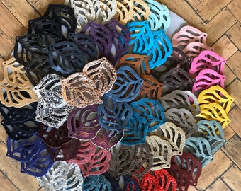 Peut inclure: Une collection de formes de feuilles en cuir de différentes couleurs, notamment noir, blanc, marron, rouge, bleu, vert, jaune et rose. Les feuilles sont disposées en spirale.