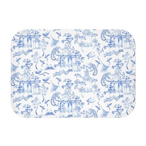 May include: A white bath mat with a blue and white repeating pattern of pagodas, flowers, and birds.
