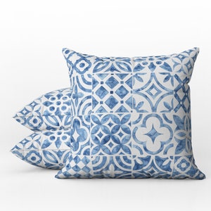 May include: Two blue and white patterned throw pillows with a geometric design. The pillows are made of a soft, comfortable fabric and are perfect for adding a touch of style to any room.