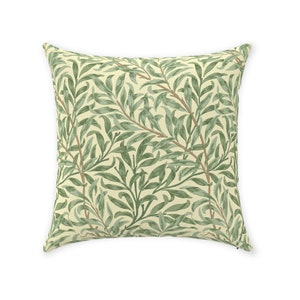 May include: A square throw pillow with a cream background and a repeating pattern of green willow branches.