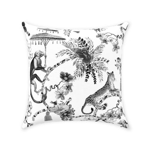 May include: Black and white throw pillow featuring a monkey sitting in a tree with an umbrella, a leopard climbing a tree, and floral designs.
