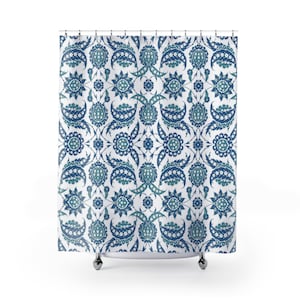 Op de afbeelding: Een wit douchegordijn met een blauw en turquoise bloemenpatroon. Het patroon is een traditioneel Turks ontwerp met ingewikkelde details.