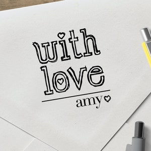 May include: White envelope with a black ink stamp that reads "with love amy" with a small heart symbol after "love" and "amy".