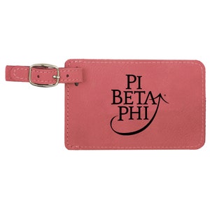 May include: Pink leather luggage tag with a black Pi Beta Phi logo and a silver buckle.