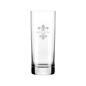 Puede incluir: Un vaso alto de vidrio transparente con un dise&ntilde;o de flor de lis esmerilado y la palabra "MIDDLETON" grabada en la parte delantera.