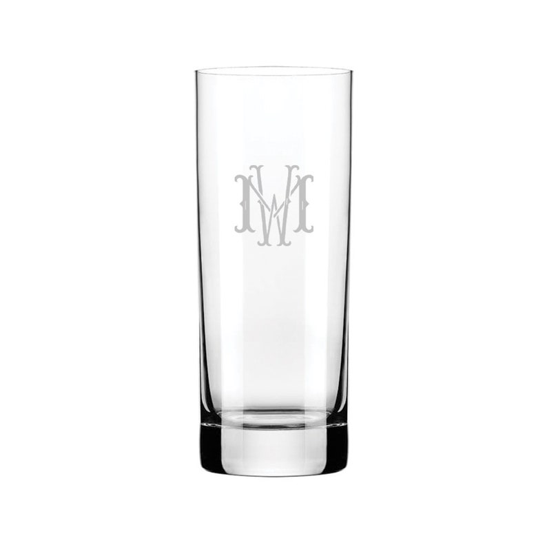 Puede incluir: Un vaso alto de vidrio transparente con un monograma "MW" grabado en la parte delantera.