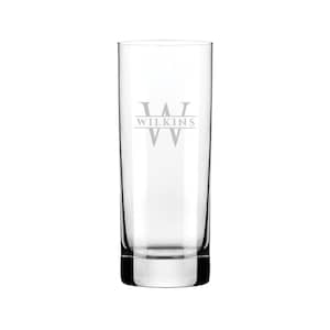 Puede incluir: Un vaso alto de vidrio transparente con un monograma personalizado. El vaso tiene una sola inicial "W" con el nombre "WILKINS" grabado debajo.