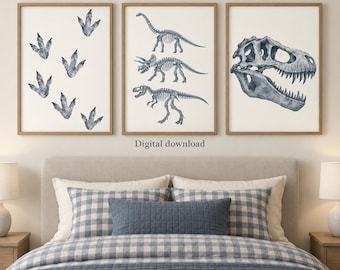 May include: Three framed wall art prints featuring blue watercolor dinosaur illustrations on a white background. The left print shows dinosaur footprints, the center print displays three full dinosaur skeletons, and the right print shows a large skull.
