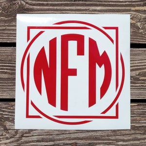 May include: Red monogram decal with the letters NFM in a circle with a square frame.