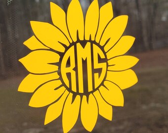 May include: A yellow sunflower decal with a black circle in the center. The circle contains the letters "RMS" in a black, stylized font.