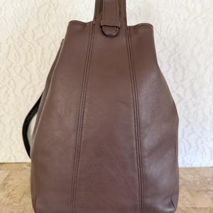 May include: A rustic wooden sign with the text "Welcome to our home" in white lettering. The sign features a distressed finish and a simple, inviting design, perfect for a front porch or entryway.