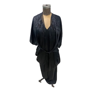 May include: A black satin robe with a tie belt and short sleeves. The robe has a delicate floral pattern.