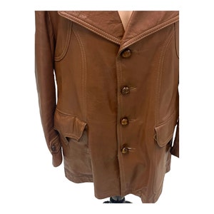 Peut inclure: Une veste en cuir marron avec un col, quatre boutons et deux poches.