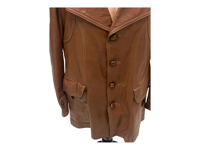 Peut inclure: Une veste en cuir marron avec un col, quatre boutons et deux poches.