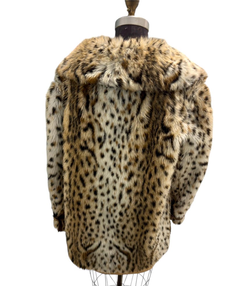 May include: A brown and white leopard print faux fur coat with a large collar.