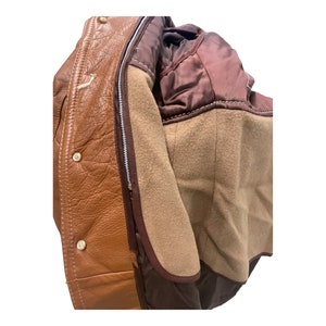 Peut inclure: Une veste en cuir marron avec une fermeture &eacute;clair et une doublure en polaire marron. La veste a une doublure en satin marron au col.