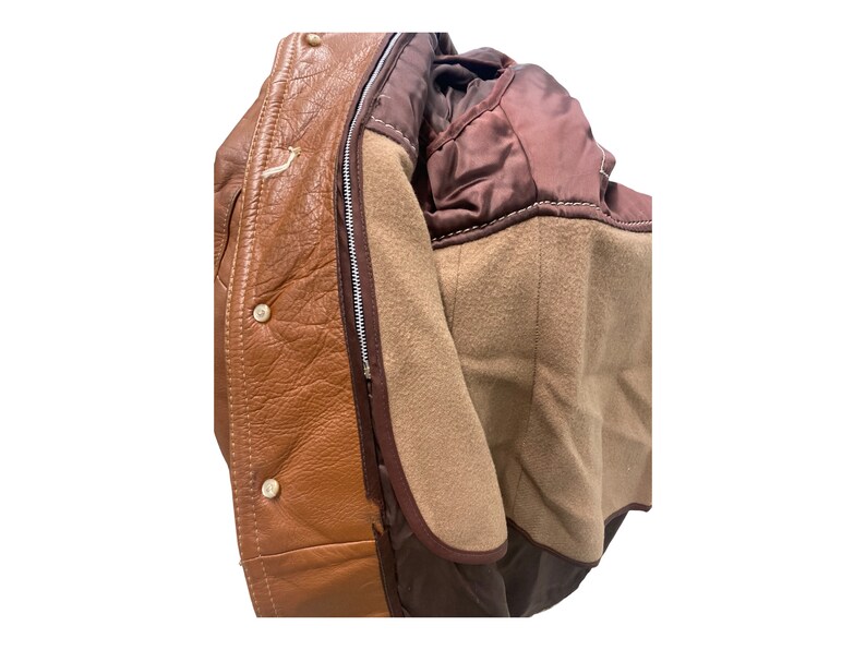 Peut inclure: Une veste en cuir marron avec une fermeture &eacute;clair et une doublure en polaire marron. La veste a une doublure en satin marron au col.