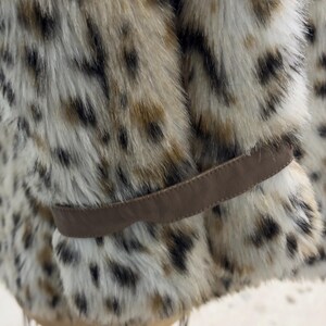 May include: A brown faux fur jacket with a leopard print pattern. The jacket has a brown leather belt.
