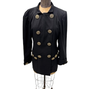 May include: A black double-breasted jacket with gold-toned buttons. The jacket has a slightly fitted silhouette and long sleeves.