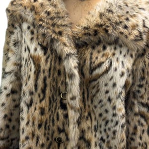 May include: A brown and white leopard print faux fur coat with a large collar and button closure.
