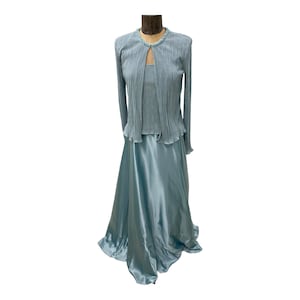 May include: A light blue two-piece dress with a long-sleeved cardigan and a satin skirt.
