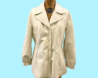 May include: A cream-colored leather jacket with a button-up front and long sleeves. The jacket has a collar and a fitted silhouette.
