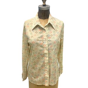 May include: A long-sleeved button-down shirt with a white background and a geometric pattern in shades of blue, green, brown, and pink.
