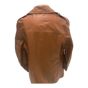Peut inclure: Une veste en cuir marron avec une fermeture &agrave; boutons et un col. La veste a deux poches sur le devant et une seule poche sur la manche gauche.