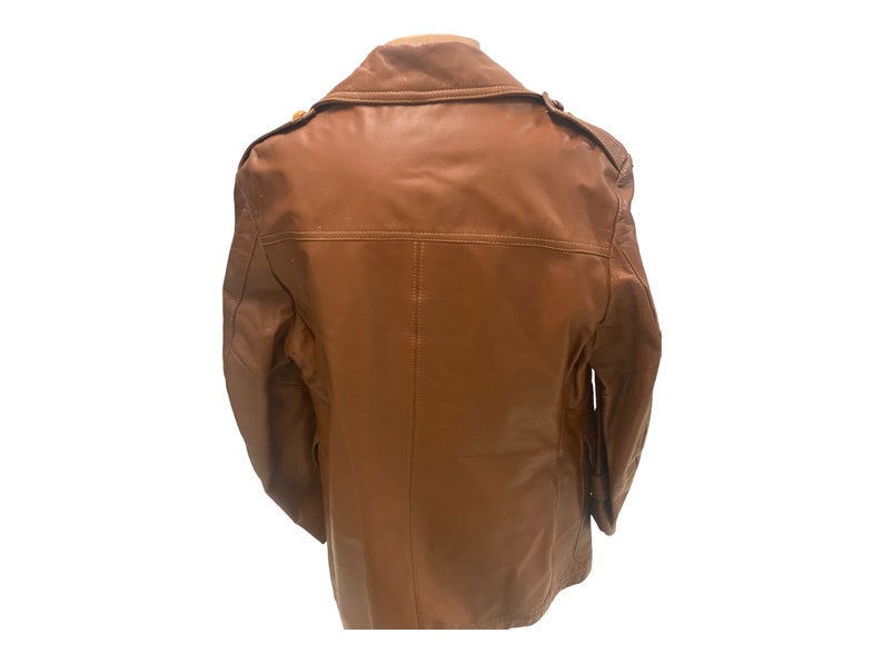 Peut inclure: Une veste en cuir marron avec une fermeture &agrave; boutons et un col. La veste a deux poches sur le devant et une seule poche sur la manche gauche.