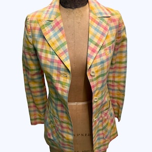 May include: A pastel pink, yellow and blue plaid blazer with two front pockets and a single button closure.