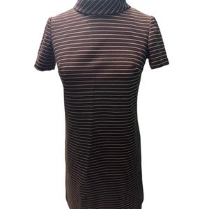 May include: A brown and white striped dress with a mock neck and short sleeves. The dress has a fitted silhouette and a pattern of horizontal white stripes against a brown background. The dress is displayed on a white background.