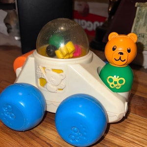 Fisher Price Poppity Pop Car. Push the car and watch the multicolored balls inside plastic bubble go "pop pop pop'! Orange spinner back 1988