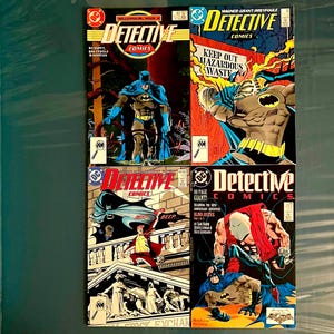 Puede incluir: Cuatro cómics vintage de "Detective Comics" con Batman. Las portadas muestran ilustraciones vibrantes de Batman en acción, con texto y logotipos en negrita. Los cómics están en buen estado, mostrando arte clásico de cómics.