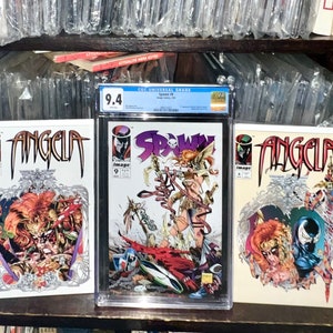 Op de afbeelding: Drie stripboeken, twee met het personage Angela en een met Spawn. De Spawn-strip is beoordeeld met 9,4 en bevindt zich in een beschermende plastic hoes. Alle drie stripboeken zijn in uitstekende staat.