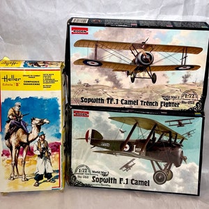 May include: Three model airplane kits in their original boxes. The top box features a Sopwith TF.1 Camel Trench Fighter in a 1:72 scale. The middle box features a Sopwith F.1 Camel in a 1:72 scale. The bottom box features a camel and two figures in a desert setting.